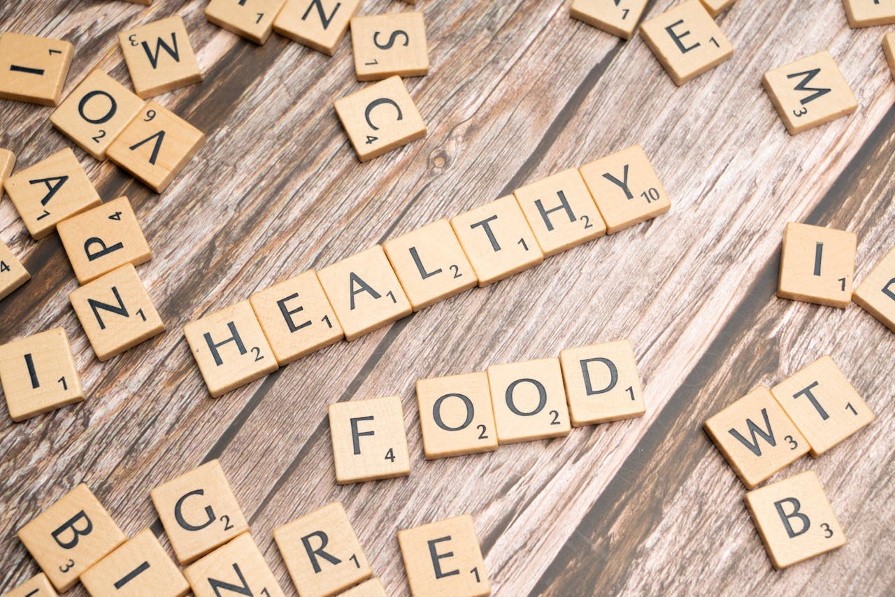 Wooden tiles spelling 'healthy food' on a wooden background creating a natural and organic theme.